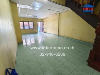 Spacious living room with tiled flooring and staircase