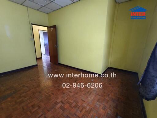 Empty bedroom with parquet flooring.