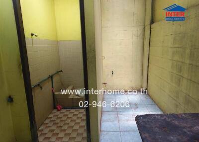 Utility room with tiled flooring and rough wall finish