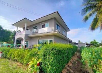 Exterior view of a two-story house with surrounding greenery