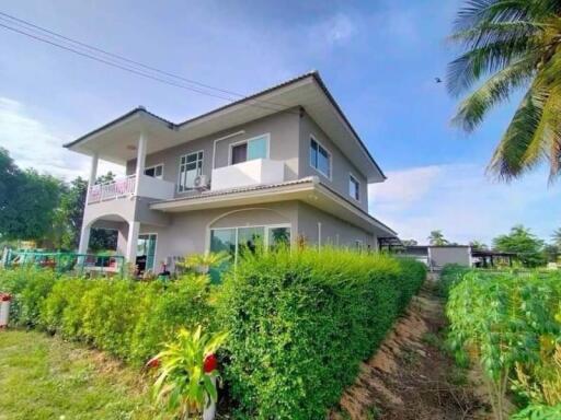 Exterior view of a two-story house with surrounding greenery