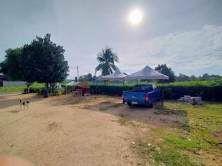 Outdoor area with tents and a blue pickup truck