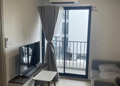 Modern living room with TV, balcony access, and air conditioning