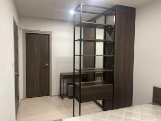 Modern bedroom with integrated shelving unit and work desk