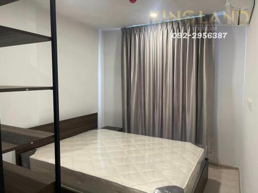 Bedroom with a double bed, curtain-covered window, and modern shelving