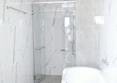 Modern bathroom with marble tiles and glass shower