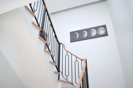 Modern staircase with moon phase artwork