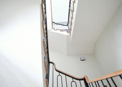 Modern staircase with wooden railings and white walls