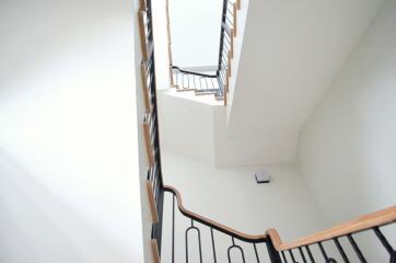 Modern staircase with wooden railings and white walls