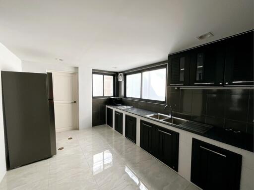 Modern kitchen with black cabinets and stainless steel appliances