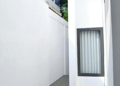 Narrow outdoor passage with white walls