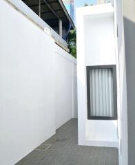 Narrow outdoor passage with white walls