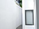 Narrow outdoor passage with white walls