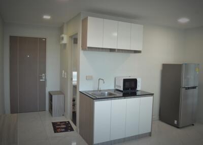 Compact modern kitchen with white cabinetry and appliances