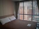 Bedroom with large window and brown bedspread