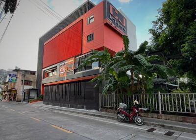 Modern multi-story commercial building with vibrant red accents