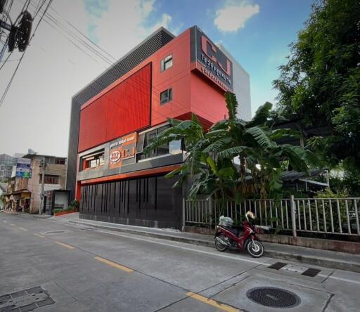 Modern multi-story commercial building with vibrant red accents