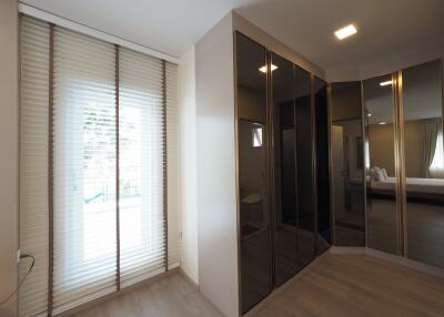 Bedroom with large mirrored wardrobe and window with blinds