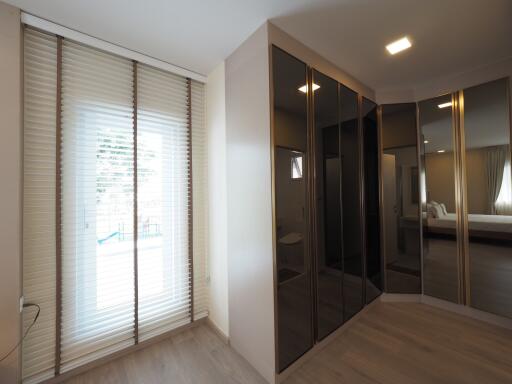 Bedroom with large mirrored wardrobe and window with blinds