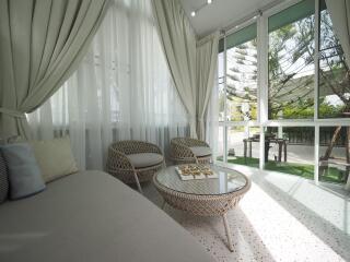 Sunroom with large windows and wicker furniture