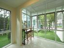 Enclosed sunroom with large windows and garden view