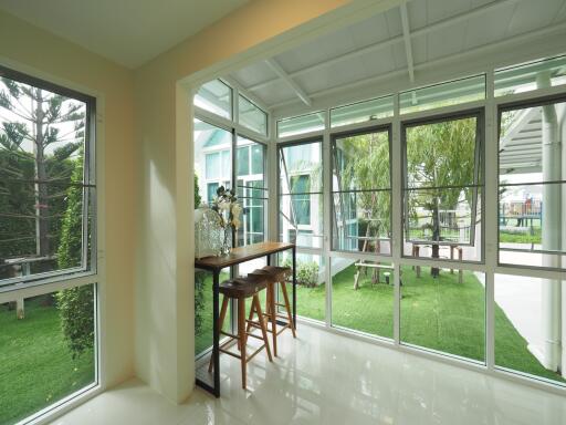 Enclosed sunroom with large windows and garden view