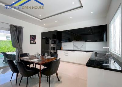 Modern kitchen and dining area with black and white cabinetry