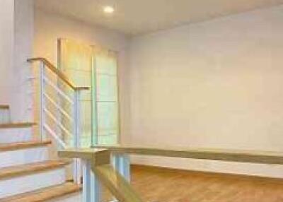 Staircase leading to a well-lit living space with wooden flooring