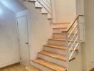 Staircase with wooden steps and white railing