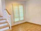 Main living area with wooden floor and staircase