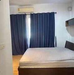 Bedroom with curtains, bed frame, and air conditioning unit