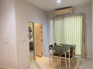 Dining area with table and chairs adjacent to kitchen and door to balcony