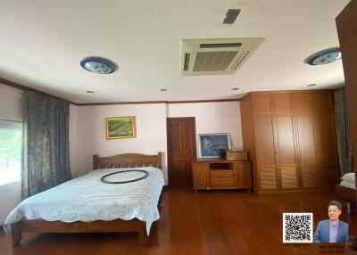 Spacious bedroom with wood flooring, large bed, and built-in wardrobes