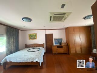 Spacious bedroom with wood flooring, large bed, and built-in wardrobes