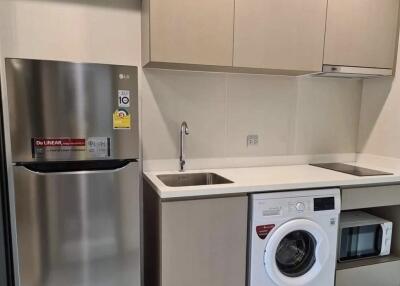 Modern kitchen with stainless steel appliances and laundry area