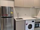 Modern kitchen with stainless steel appliances and laundry area