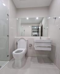 Modern bathroom with toilet, sink, and shower