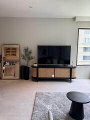 Modern living room with television, mirror, potted plant, and coffee table