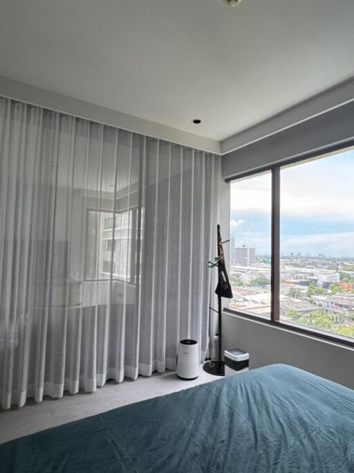 Bedroom with large window and city view