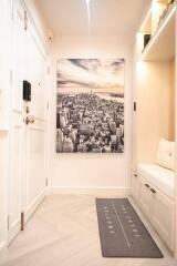 Entryway with white door, cityscape artwork, and built-in seating with storage