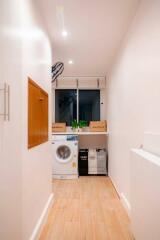 Laundry room with washing machine and storage