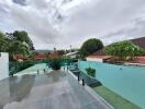 Outdoor area with a swimming pool and patio surrounded by greenery