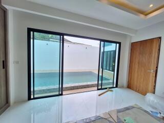 Living room with sliding glass doors leading to a private pool