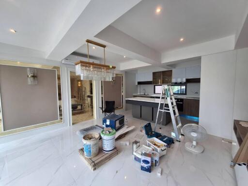 Living area under renovation with chandelier and construction materials