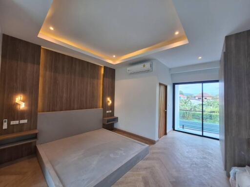 Modern bedroom with large windows and wooden accents