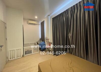 Bedroom with crib, air conditioner, and curtains