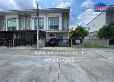 Front view of a two-story townhouse with paved driveway