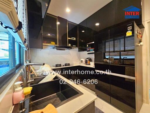 Modern kitchen with black cabinets and marble countertops