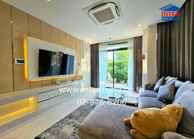 Spacious living room with modern furnishings and a large window.