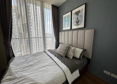 Modern bedroom with large windows and framed artwork